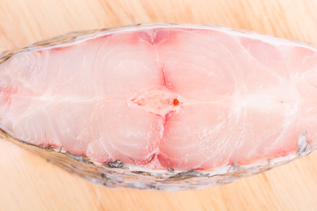 Piece of tilapia fish meat on wooden background