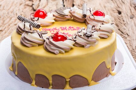 birthday chocolate cake topped with banana on wooden tableの写真素材