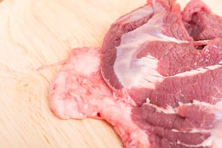 fresh raw beef meat slices on wooden for cooking on wood tableの写真素材