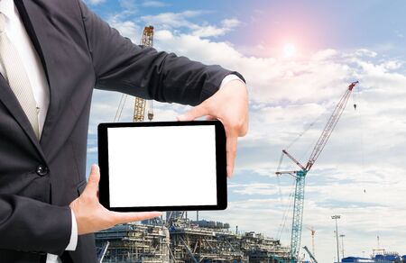 Engineering working hold tablet in front of construction site.の写真素材