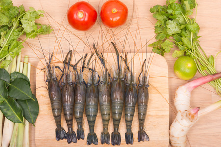 Raw tiger Fresh shrimps with vegetables Spicy Soup and herbs on wooden dark backgroundの写真素材