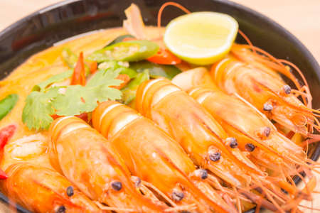 Tom Yum Goong, Thai hot spicy soup shrimp on Black Cup with wooden table, Thailand Foodの写真素材