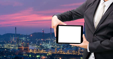 Engineering working hold tablet in front of oil refinery power stationの写真素材