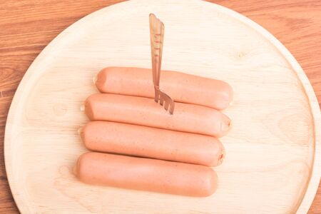Heap sausages with dish wood on wooden tableの写真素材