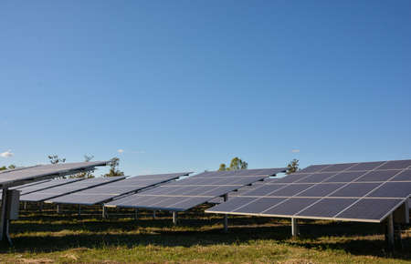 Photovoltaic solar panels on green grass with blue skyの写真素材