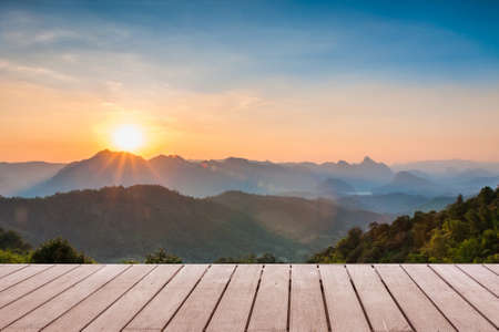 Wood table top on Majestic sunset in the mountains landscape background can put or montage your productsの写真素材