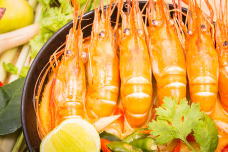 Tom Yum Goong, Thai hot spicy soup shrimp on Black Cup with wooden table, Thailand Foodの写真素材