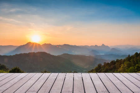 Wood table top on Majestic sunset in the mountains landscape background can put or montage your productsの写真素材