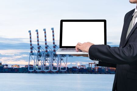 Engineering working hold conputer notebook in front of industrial harbor cargoの写真素材