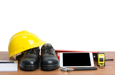 yellow helmet and tablet tools on wooden table with white backgroundの写真素材