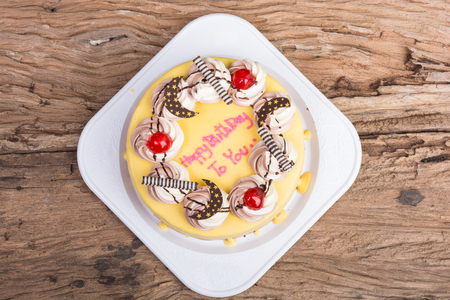 birthday chocolate cake topped with banana on wooden tableの写真素材