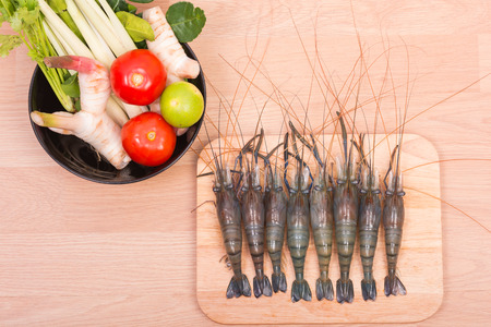 Raw tiger Fresh shrimps with vegetables Spicy Soup and herbs on wooden dark backgroundの写真素材