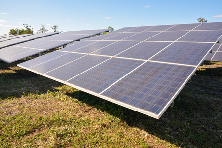 Photovoltaic solar panels on green grass with blue skyの写真素材