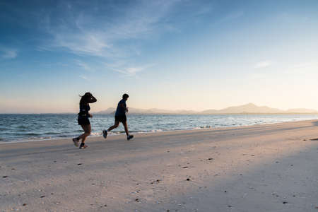 silhouette running on the island beach with sunrise at koh rok, Thailandの写真素材