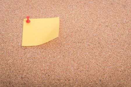 Yellow blank note papers with pin on wooden board backgroundの写真素材