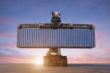 Forklift handling container box loading in the port at Thailand at sunsetの写真素材