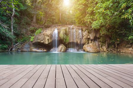 Wooden plank and background with Waterfall in Erawan Parkの写真素材