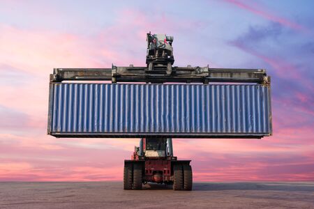 Forklift handling container box loading in the port at Thailand at sunsetの写真素材