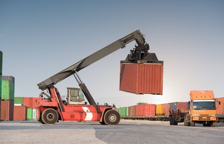 forklift handling container loading box from freight train to the truckの写真素材