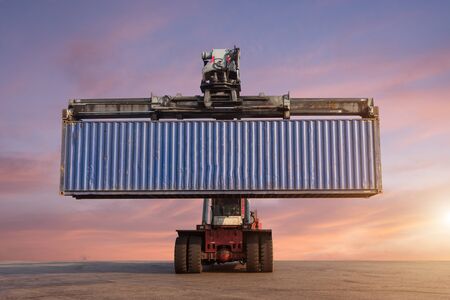 Forklift handling container box loading in the port at Thailand at sunsetの写真素材