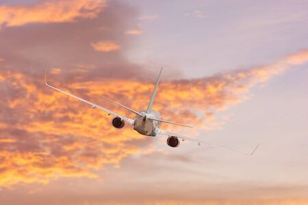 Airplane aft plane in the sky at sunset skyの写真素材