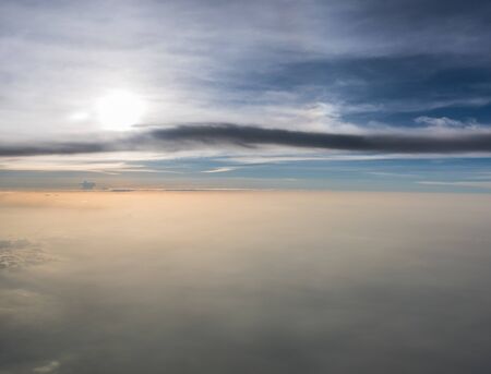 Many cloud in Flying above sunrise, view from outside airplane