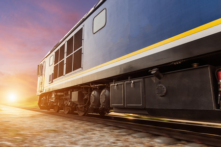 High speed diesel train on tracks with motion blur at sunset