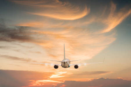Airplane aft plane in the sky at sunset skyの写真素材