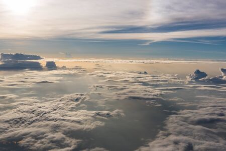 Many cloud in Flying above sunrise, view from outside airplane