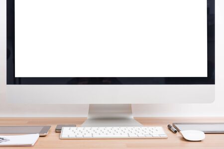 Monitor computer PC, keyboard, Phone, magic mouse and tablet on wooden deskの写真素材