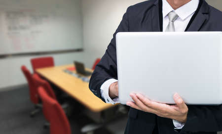 Businessman hold laptop computer in meeting roomの写真素材