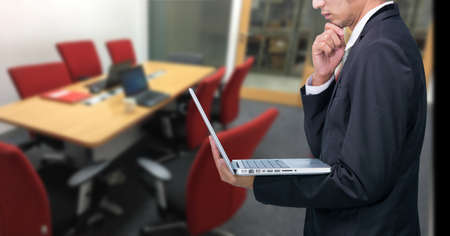Businessman hold laptop computer in meeting roomの写真素材
