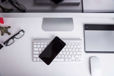 Office Computer on white wooden table and mobile phoneの写真素材