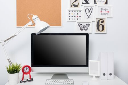 Modern home office computer monitor workspace on white deskの写真素材