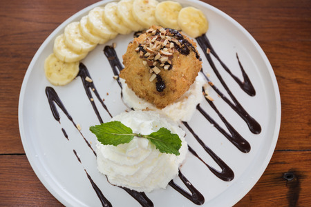 Fried ice cream served on wooden table backgroundの写真素材