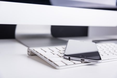 Office Computer on white wooden table and mobile phoneの写真素材