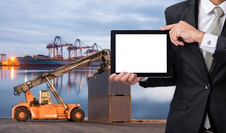 Foreman or working man hold tablet control loading Containers box to Logistic cargo Import Export Backgroundの写真素材