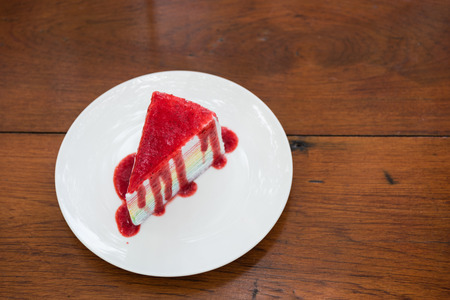 Sliced tasty strawberry cake on wooden table backgroundの写真素材