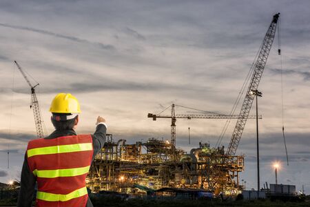 Worker man watching some details on constructionの写真素材