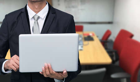 Businessman hold laptop computer in meeting roomの写真素材