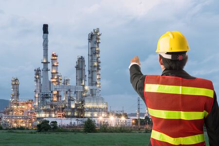 Petrochemical engineering man with white safety helmet standing in oil refinery building structure petrochemical industryの写真素材
