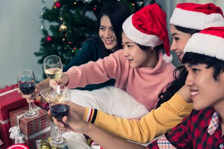 Group of friends celebrating Christmas at home and caps toasting with champagne, Christmas or New Year conceptの写真素材