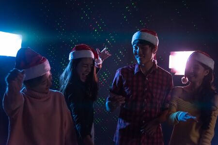 Group Asian young friends dancing Together party celebrating Christmas at dark home, Christmas or New Year conceptの写真素材