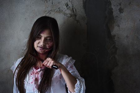 Ghost woman or Zombie holding knife Slit throat itself in room house ,halloween conceptの写真素材