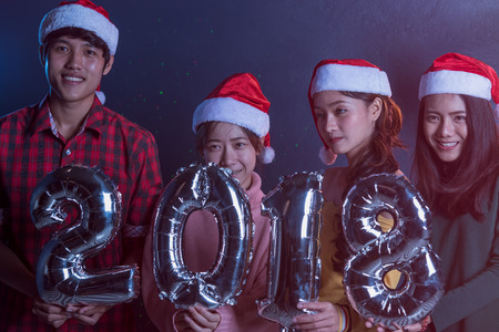 Group Asian young friends Holding wording 2018 Together party celebrating Christmas at dark home, Christmas or New Year conceptの写真素材