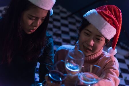 Group Asian young friends Enjoying Evening Drinks together party with Disco lights celebrating...