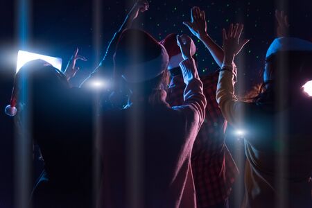 Group Asian young friends dancing Together party with Disco lights celebrating Christmas at dark home, Christmas or New Year conceptの写真素材