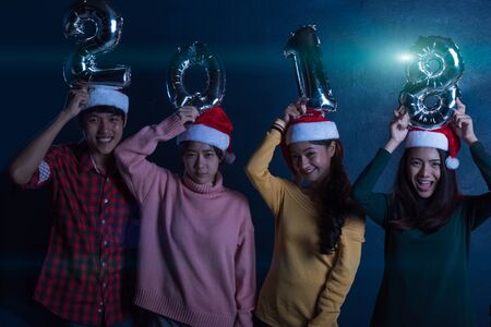 Group Asian young friends Holding wording 2018 Together party celebrating Christmas at dark home, Christmas or New Year conceptの写真素材