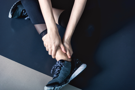 Young woman have ankle cramp in fitness exercise training in fitness gymの写真素材
