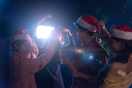 Group Asian young friends dancing Together party celebrating Christmas at dark home, Christmas or New Year conceptの写真素材